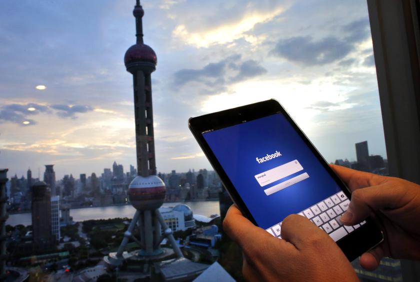 In this photo illustration, a man holds an iPad with a Facebook application in an office building at the Pudong financial district in Shanghai, September 25, 2013. u00e2u20acu201d Reuters pic