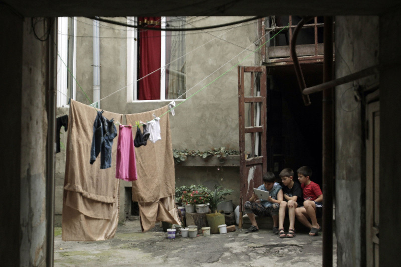 Children use an iPad as they sit in a courtyard in Tbilisi July 18, 2013. u00e2u20acu201d Reuters pic
