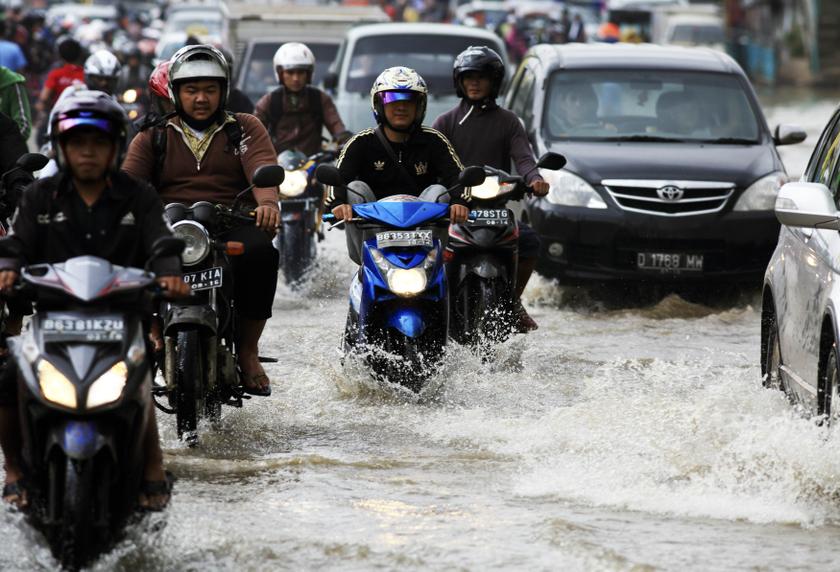 People ride their motorcycles through a flooded street in Jakarta, January 24, 2014. u00e2u20acu201d Reuters pic