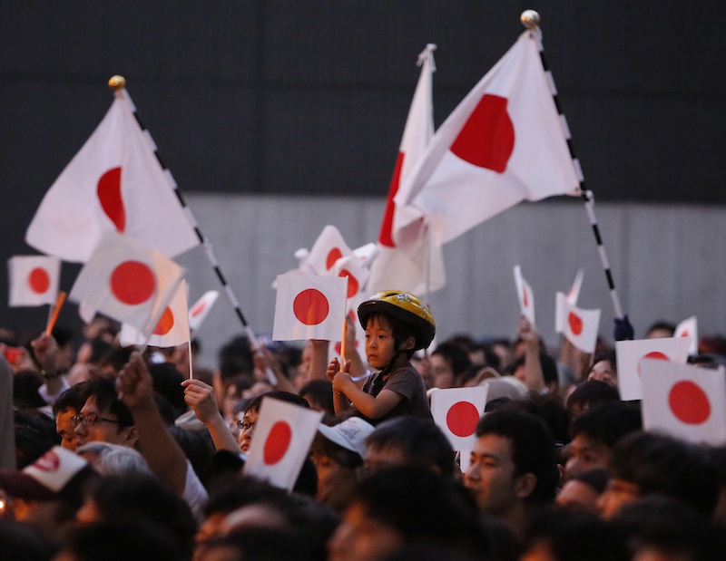 People wave Japanu00e2u20acu2122s national flags as Japanu00e2u20acu2122s Prime Minister Shinzo Abe, and the leader of the ruling Liberal Democratic Party, speaks to voters during campaigning for the July 21 Upper house election in Tokyo July 20, 2013. u00e2u20acu201d Reuters pic