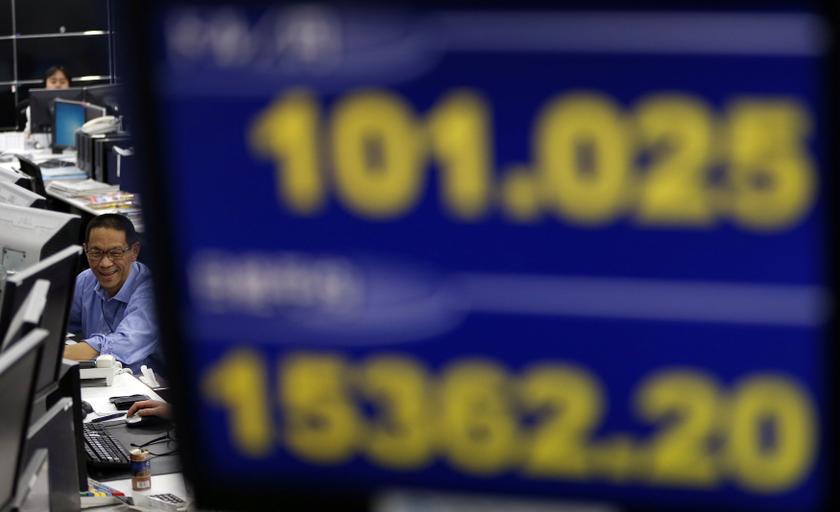 An employee of a foreign exchange trading company works near a monitor displaying the Japanese yen's exchange rate against the US dollar (top), and Nikkei share average in Tokyo November 22, 2013. u00e2u20acu201d Reuters pic