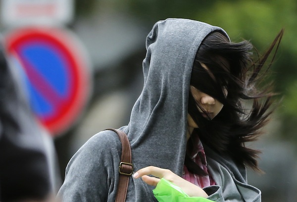 A womanu00e2u20acu2122s hair blows across her face as she struggles to walk in a strong wind caused by an approaching tropical storm Man-yi, also called locally Typhoon No.18, in Tokyo September 16, 2013. u00e2u20acu201d Reuters pic