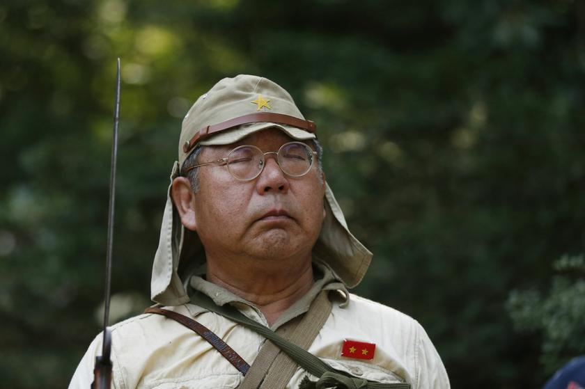 A man dressed as a Japanese imperial soldier observes a moment of silence at the shrine.