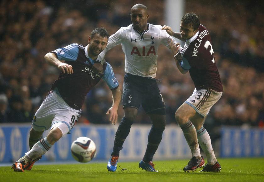 File photo shows Jermaine Defoe (centre) of Tottenham Hotspur being held by Razvan Rat (left) and George MacCartney of West Ham United during their English League Cup quarter-final soccer match at White Hart Lane, London, December 18, 2013. Defoe will lea