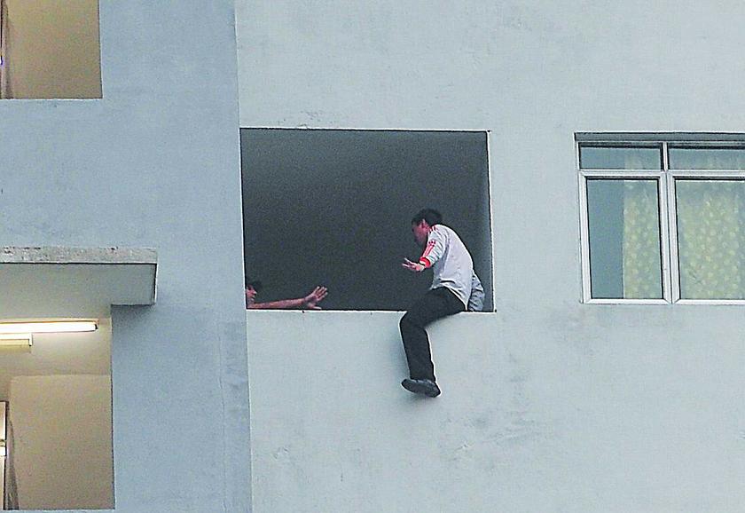 The Malay Mail investigative journalist Haresh Deol coaxes the man to get off the ledge on the 15th floor of the Millennium Square Condominium in Section 14, Petaling Jaya in the suspenseful turn of events on July 31, 2013. u00e2u20acu201d The Malay Mail picture
