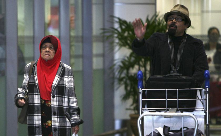 Kamar Mahtum, sister of Siti Aishah Abdul Wahab, and activist Hishamuddin Rais walk out from the arrival gate after returning from London, at Kuala Lumpur International Airport, December 1, 2013. u00e2u20acu201d Reuters pic