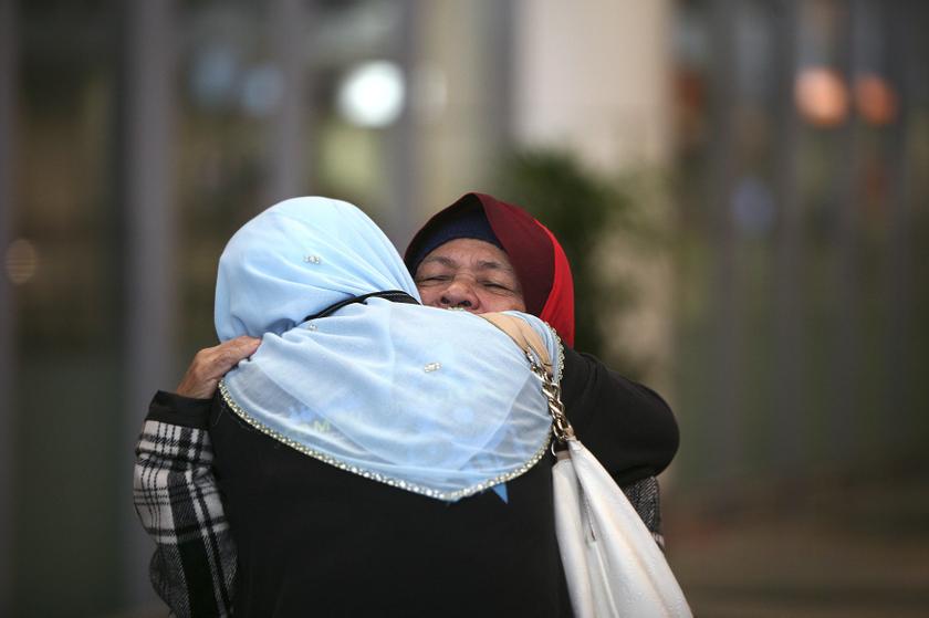 Kamar Mahtum (right), sister of Siti Aishah Abdul Wahab, hugs a family member after arriving at Kuala Lumpur International Airport December 1, 2013. u00e2u20acu201d Reuters pic