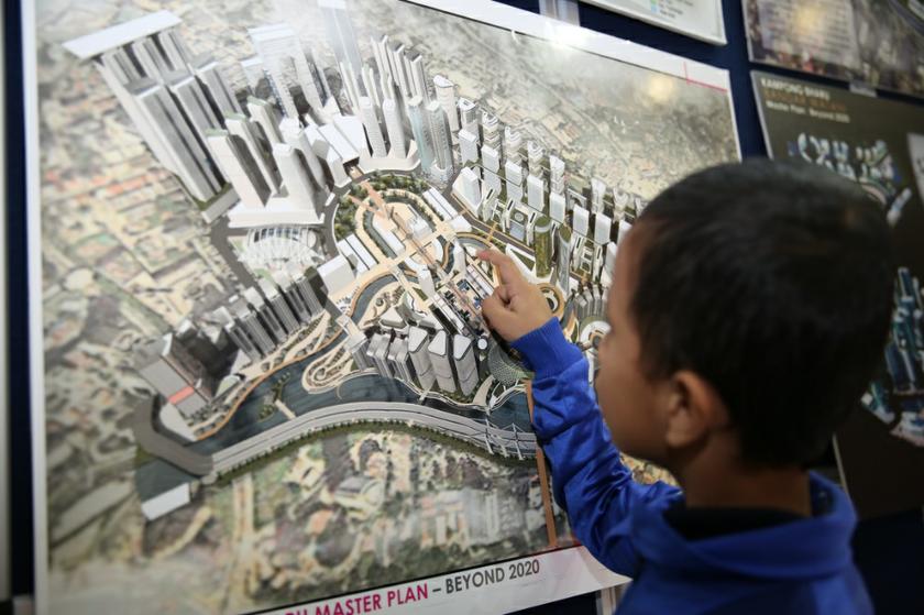 A child points at one of the proposed master plans for Kampung Baruu00e2u20acu2122s redevelopment. u00e2u20acu201d Picture by Saw Siow Feng
