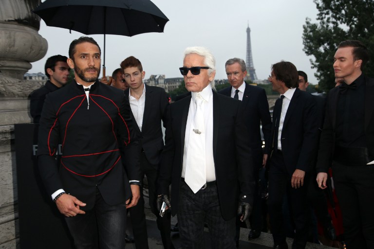 German fashion designer Karl Lagerfeld (centre) arrives for the opening of his photo exhibition ‘The GLory of Water’ under the Alexandre III Bridge on July 3, 2013 in Paris. — AFP pic
