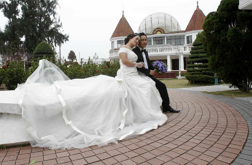 A couple pose for their wedding photo in front of Do Son casino in Vietnam's northern Hai Phong port city February 10, 2014 Reuters