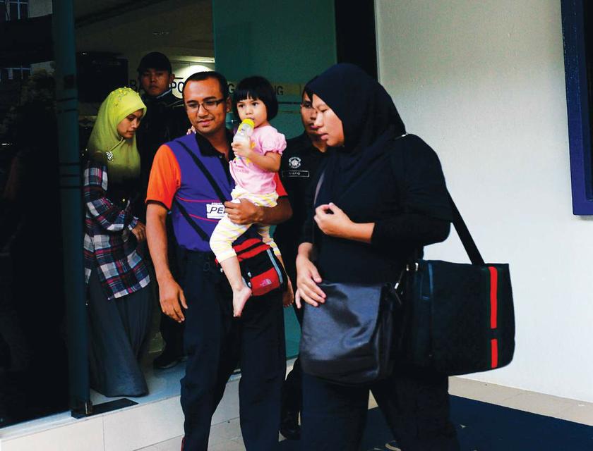 Wan Aisyah Wan Exzam being carried out from the Sungai Nibong police station by her father on August 5, 2013. u00e2u20acu201d Picture by Azrol Ali