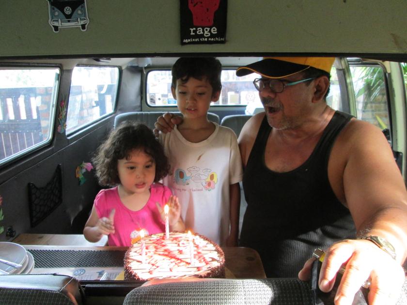 Jenol's grand-daughter blowing out the candles on her birthday cake in the Kombi. 