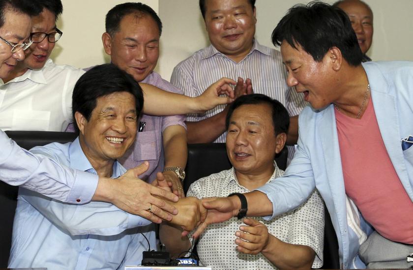 South Korean businessmen, who run factories in the Kaesong Industrial Complex inside North Korea, celebrate after they hear the news that the two Koreas agreed to restart the troubled joint industrial park in Seoul August 14, 2013