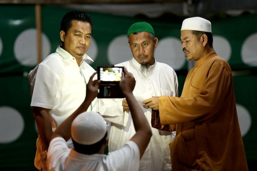 A PAS supporter takes a group photo with PAS candidate Azlan Yusof (centre) in Kuala Besut on July 11, 2013. u00e2u20acu201d Picture by Saw Siow Feng