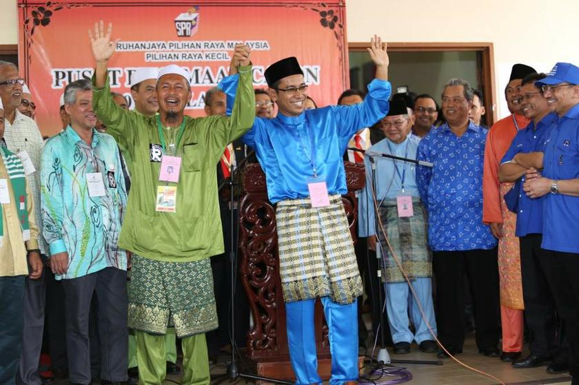PAS candidate Azlan Yusof (in green) and Barisan Nastional candidate Tengku Zaihan Che Ku Abdul Rahman (in blue) wave to supporters at the Kuala Besut by-election nomination centre on July 12, 2013. u00e2u20acu201d Picture by Saw Siow Feng