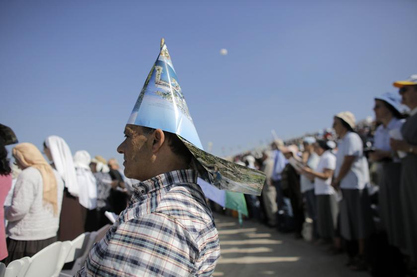 A Christian worshipper wears a paper hat during a mass led by Latin Patriarch of Jerusalem Fouad Twal on Mount Precipice in the northern Israeli city of Nazareth November 17, 2013.