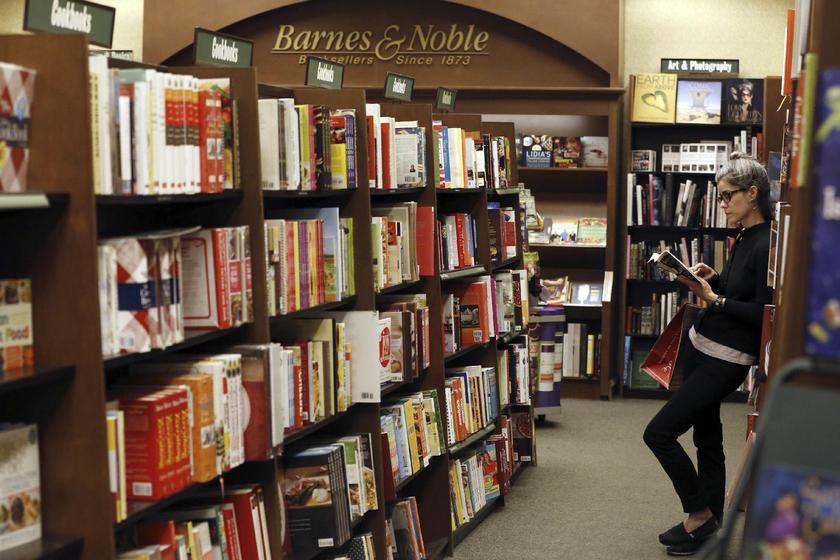 A woman lost in a book at a Barnes & Noble bookstore in Pasadena, California, November 26, 2013. Largest U.S. bookstore chain Reuters