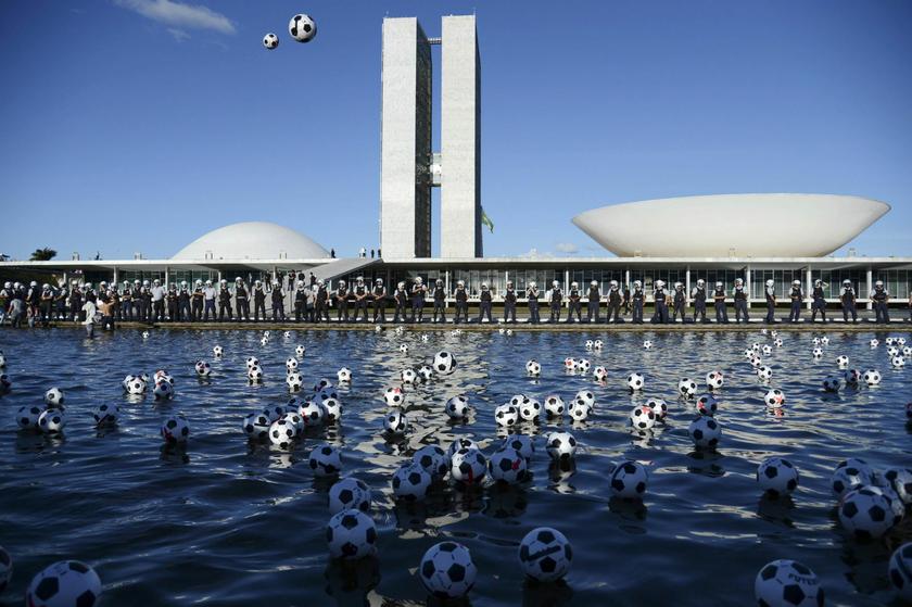 Soccer balls marked with red crosses float after being kicked as a protest by members of NGO Rio de Paz (Rio Peace) into the fountain in front of National Congress in Brasilia June 26, 2013. 