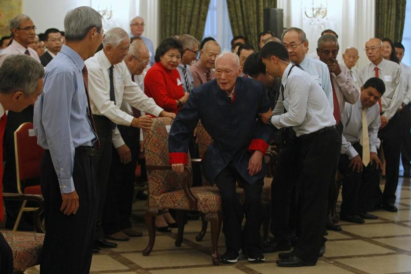 Singapore's former Prime Minister Lee Kuan Yew (C) looks at his son Prime Minister Lee Hsien Loong (L) as he arrives for the launch of his book One Man's View of the World at the Istana in Singapore August 6, 2013