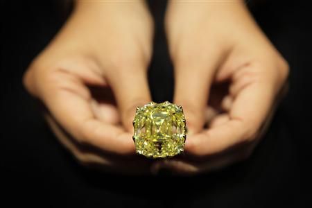 A jeweller from Vihari Jewels holds the 110-carat 'Yellow Dragon' diamond ring during the Singapore Jewelfest 2012 exhibition in Singapore October 17, 2012. u00e2u20acu201d Reuters pic