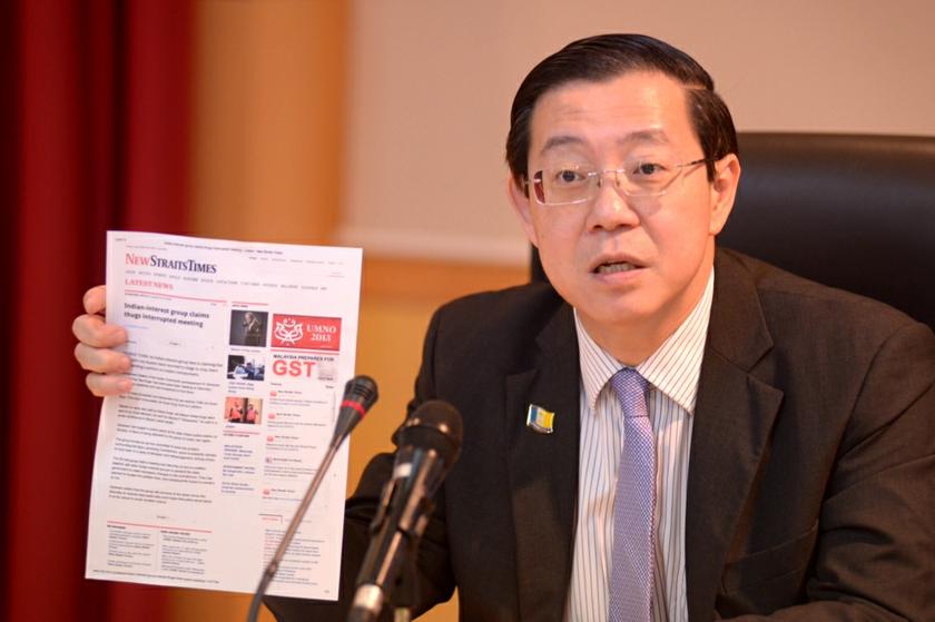 Penang Chief Minister Lim Guan Eng showing the NST article during the press conference in George Town December 6, 2013. u00e2u20acu201d Picture by K.E. Ooi