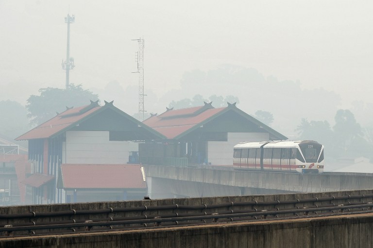 A Light Rail Transit (LRT) train travels along its tracks in Kuala Lumpur as haze covers the city on June 23, 2013. The thick smog brought on by forest fires in Indonesia has choked parts of Malaysia. u00e2u20acu201d AFP pic
