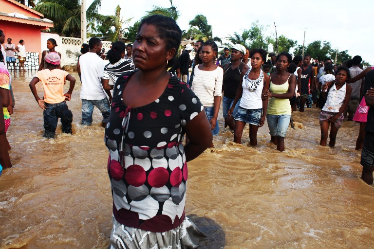 People walk on a flooded street in Tulear, Madagascar, on February 23, 2013, a day after the cyclone Haruna hit the island. u00e2u20acu201d AFP pic