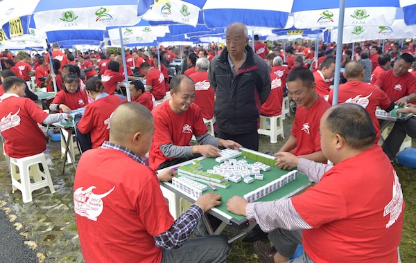People play mahjong during their attempt to break the Guinness World Records of the most number of people playing mahjong simultaneously in Dujiangyan,Chengdu, Sichuan province, September 19, 2013. u00e2u20acu201d Reuters pic