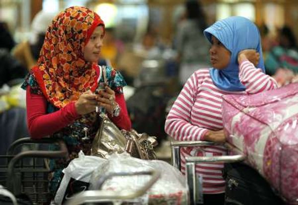 Migrant workers chat near their belongings as they wait for their documents to be processed after their arrival from Malaysia, at a special terminal for migrant workers in the Soekarno-Hatta airport in Jakarta October 28, 2009. u00e2u20acu201d Reuters pic