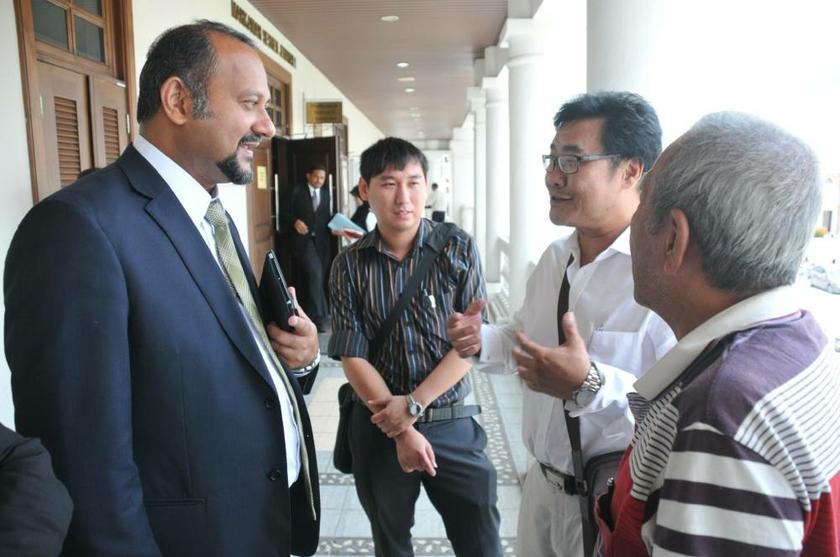 Gobind Singh Deo (left) talking to the family members of Lim Chin Aik outside the court room, at the inquest into his death