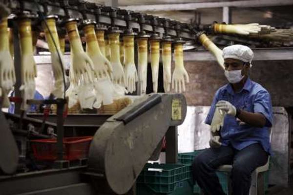 A worker monitors a production line at a glove factory in Meru on June 25, 2009. u00e2u20acu201d Reuters pic
