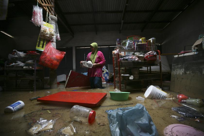 A woman collects her belongings inside a shop at Chenor, between the border state of Pahang and Terengganu, 300km outside Kuala Lumpur December 6, 2013. u00e2u20acu201d Reuters pic