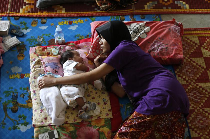 A woman rests next to her baby inside a relief centre after being evacuated at Kemaman, 300km outside Kuala Lumpur December 6, 2013. u00e2u20acu201d Reuters pic