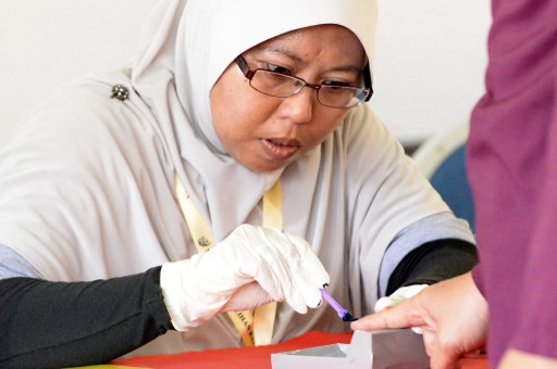 A polling clerk marks with ink a voteru00e2u20acu2122s finger at a polling station in Pekan on May 5, 2013. u00e2u20acu201d AFP pic