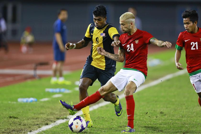 Thamil Arasu Ambumaee of Malaysia and Diego Robbie Michiels of Indonesia (right) fight for ball during the football semi-final match at the 27th SEA Games in Naypyitaw December 20, 2013. u00e2u20acu2022 Reuters pic