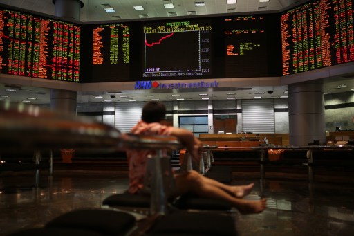 A man watches stock share index movements on a digital display screen in Kuala Lumpur on May 6, 2013. u00e2u20acu201d AFP pic