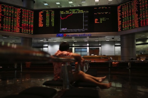 A man watches stock share index movements on a digital display screen in Kuala Lumpur on May 6, 2013. u00e2u20acu201d AFP pic