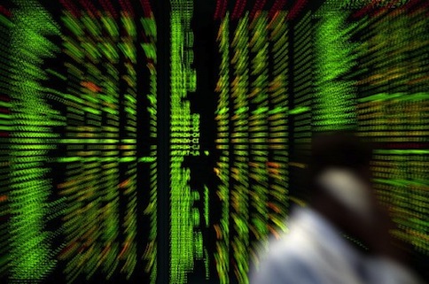 A Malaysian trader talks on a phone in front of a digital share prices board showing the Malaysian Index in Kuala Lumpur on June 18, 2012. u00e2u20acu201d AFP pic