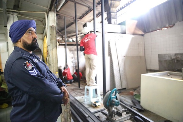 A DBKL officer observes workers at the Golden Triangle Muneswarar Kuil in Kuala Lumpur September 1, 2013. u00e2u20acu201d Picture by Choo Choy May