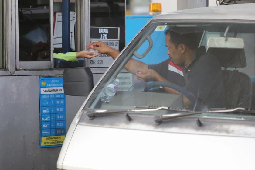 A Malaysian highway user pays a toll station in Kuala Lumpur December 18, 2013. u00e2u20acu201d Picture by Choo Choy May
