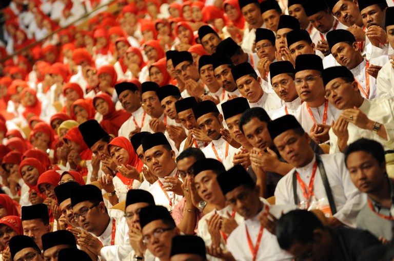 Delegates pray prior to the address of Malaysia's prime minister-in-waiting Najib Razak at an annual gathering of Malaysia's ruling United Malays National Organisation (UMNO) in Kuala Lumpur on March 24, 2009. u00e2u20acu201d AFP pic