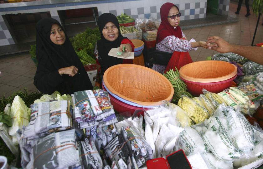Women pay their bills at a wet market in Shah Alam outside Kuala Lumpur January 22, 2014. u00e2u20acu201d Reuters pic