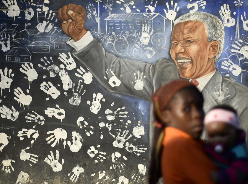 Locals stroll past a mural outside the house former President Nelson Mandela stayed at in the 1940s, in Johannesburgu00e2u20acu2122s Alexandra township June 25, 2013. u00e2u20acu201d Reuters pic