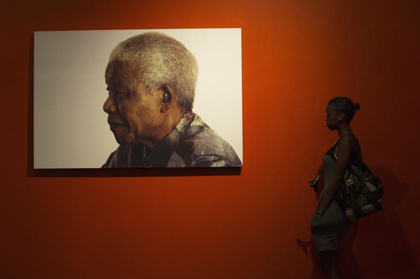 A woman stands next to a photograph of former South African President Nelson Mandela at the Nelson Mandela Centre Of Memory in Johannesburg, December 9, 2013. u00e2u20acu201d Reuters pic