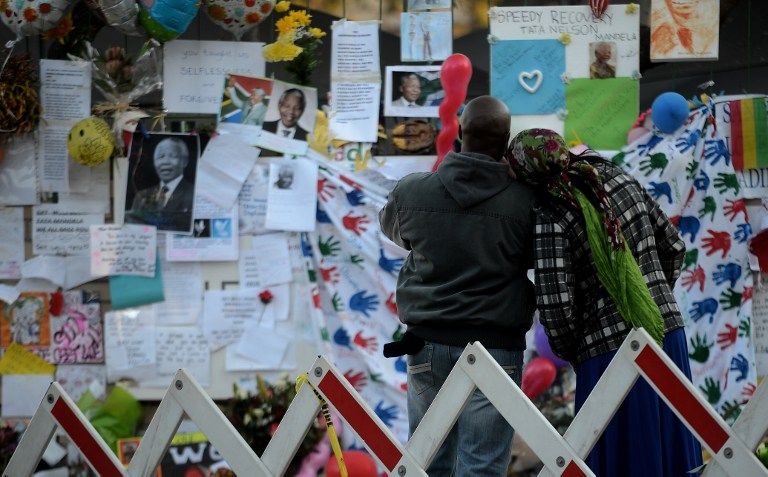People look at tributes outside the Mediclinic Heart hospital in Pretoria on June 27, 2013, where former South African Nelson Mandela is on life support.