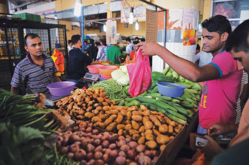 This Bangladeshi trader (right) enjoys good sales at the Plaza Sri Muda wet market in Shah Alam. u00e2u20acu201d Picture by Firdaus Latif 