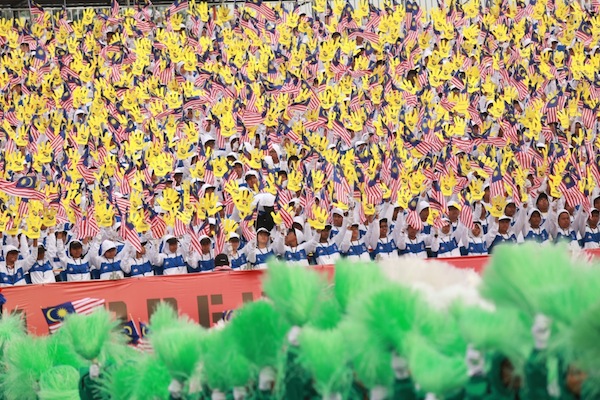 Participants wave the national flag and foam hands during the 56th National Day Parade at Dataran Merdeka in Kuala Lumpur, August 31, 2013. u00e2u20acu201d Picture by Saw Siow Feng