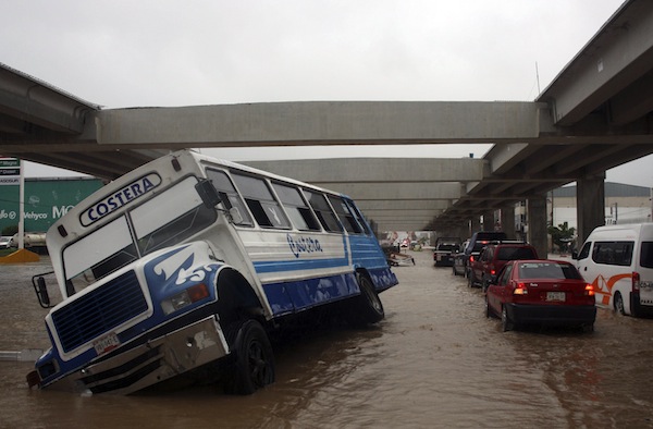 A stranded bus is seen as cars make their way through a flooded street in Acapulco September 16, 2013. Hurricane Ingrid and Tropical Storm Manuel brought heavy rains to Mexicou00e2u20acu2122s Gulf and Pacific coasts yesterday. u00e2u20acu201d Reuters pic