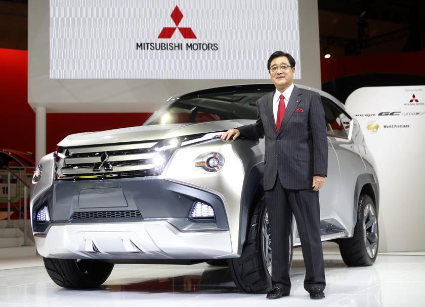 Mitsubishi Motors Corp President Osamu Masuko poses next to the companyu00e2u20acu2122s concept car GC-PHEV at the 43rd Tokyo Motor Show November 20, 2013. u00e2u20acu2022 Reuters picn