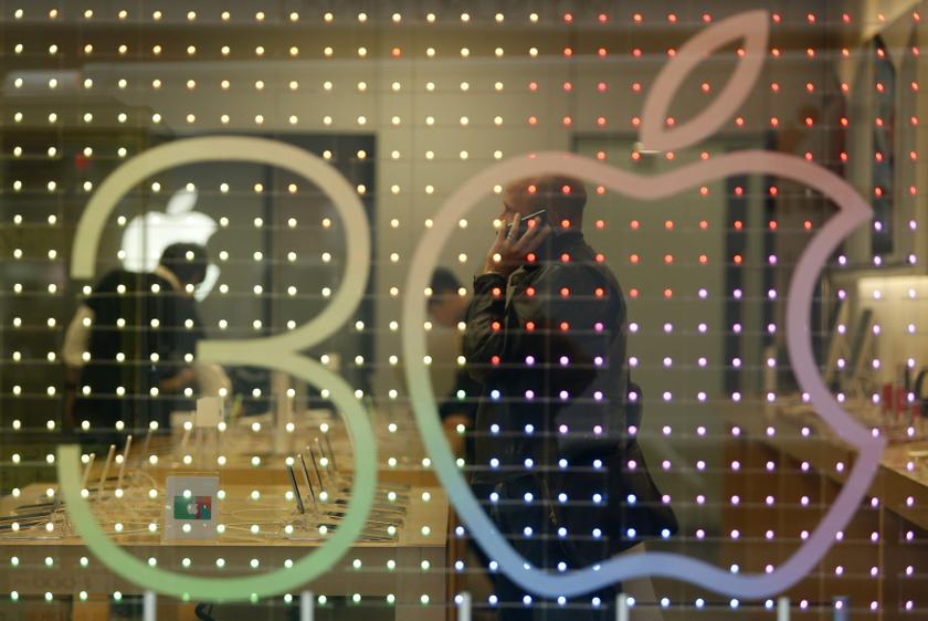 A man using his mobile phone is seen through a sign advertising the 30th anniversary of the Macintosh computer at an Apple shop in Tokyo's Ginza shopping district January 30, 2014. u00e2u20acu201d Reuters pic